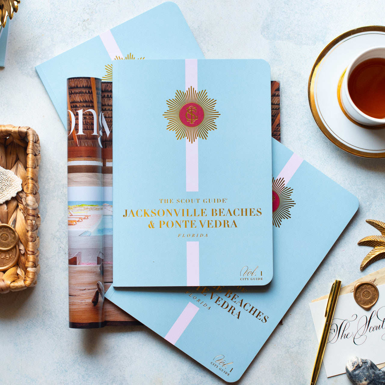 The Scout Guide Jacksonville Beaches & Ponte Vedra Volume 1, baby blue cover cover with light pink stripe, gold foil title and TSG Medallion logo