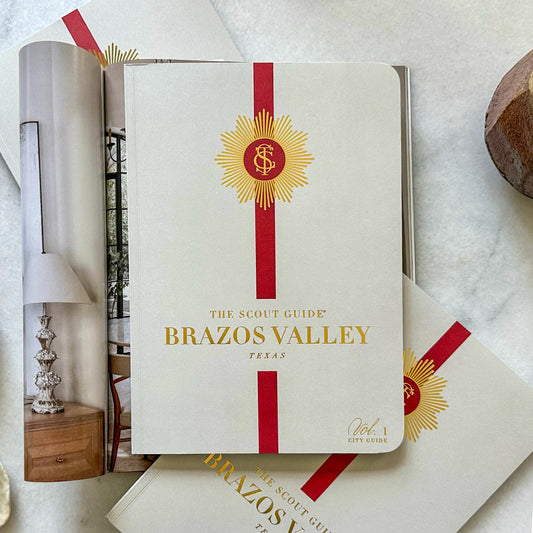 The Scout Guide Brazos Valley, Volume 1, taupe cover with red stripe, gold foil title and TSG Medallion