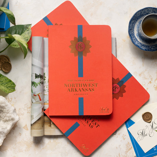The Scout Guide Northwest Arkansas Volume 8, bright orange cover with blue stripe, gold foil title and TSG Medallion logo